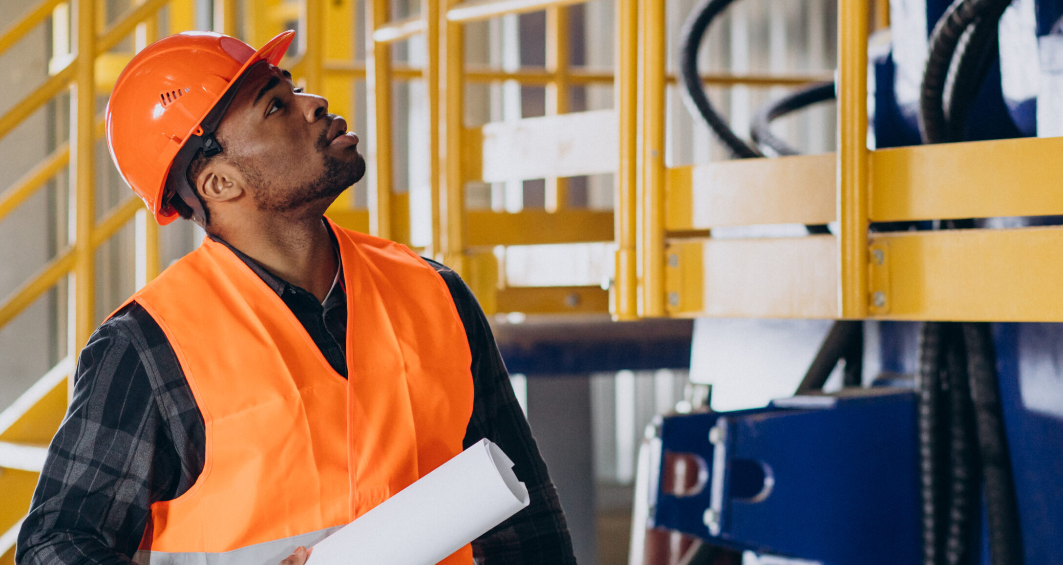 African american worker standing in uniform wearing a safety hat in a factory